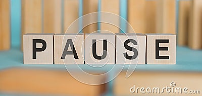PAUSE word written on wooden blocks on light blue background Stock Photo