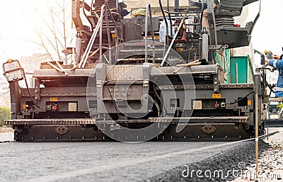 Paver machine is laying fresh asphalt on city road Stock Photo