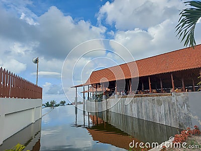 a pavilion with a pool filled with water around it with a bright blue sky as a background Editorial Stock Photo