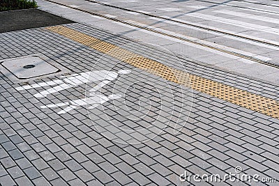 Paving footpath with painted warning sign and crosswalk on railway road Stock Photo