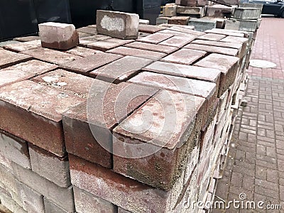 Paving stone red cement tile for laying road construction, pavement on wooden pallets at a construction site Stock Photo