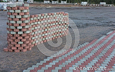 Paving stones are laid on the construction site or paving slabs in even rows, alternating red and gray.A castle and a wall were Stock Photo