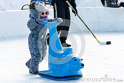 Pavlovsky Ski Park, Russia - March 10, 2018: child on the rink with ice skating support Editorial Stock Photo