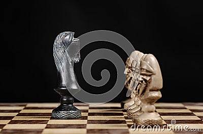 Pawn chess pieces facing the knight on a chessboard Stock Photo