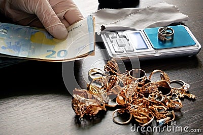 pawnshop worker counts money for gold jewelry on many golden and silver jewelleries background. Customers Buy and Sell Precious Stock Photo