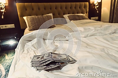 paying money dollar on white bed in hotel Stock Photo