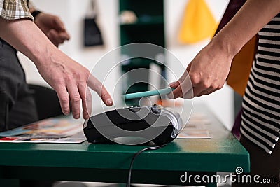 Close-up of a customer attaching smartphone to the payment terminal Stock Photo