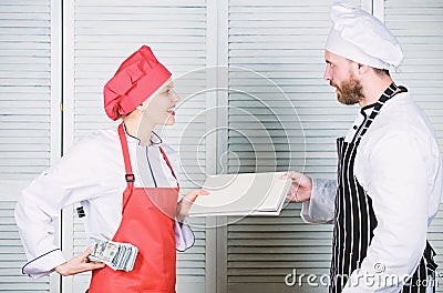 Paying wage. Female bookkeeper with account report paying money wage. Restaurant balance book. Master cook and helper Stock Photo