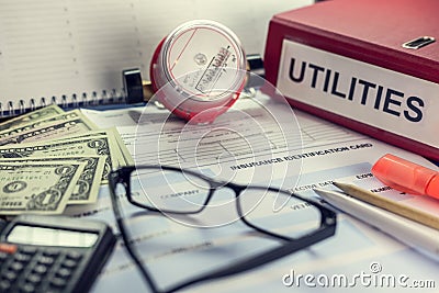 Payment of utilities for electricity and water: receipt, bills and a calculator. On the folder the inscription Stock Photo