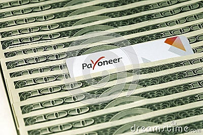 Payoneer prepaid plastic card amongst dollar bills Editorial Stock Photo