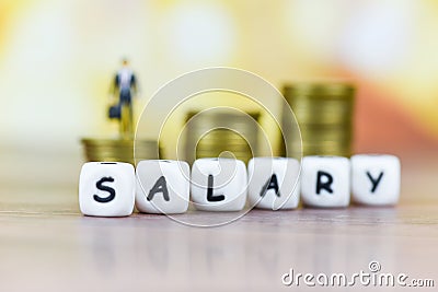 Payroll and salaries ladder increase growth money coins on table and success concept - salary text block with bussiness man Stock Photo
