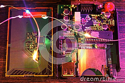 PCB with microchip, microprocessor, wires, neon lights, qubit on the table Stock Photo