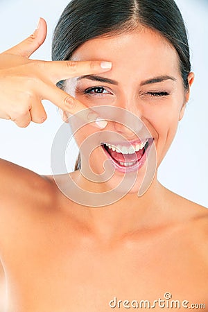 Peace hands, skincare and portrait of happy woman with wink in studio for wellness on white background. V, eyes and Stock Photo