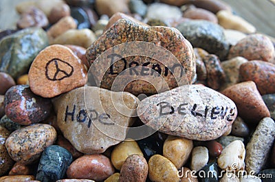 Peace, Hope, Dream and Believe Handwritten on River Rock Stock Photo