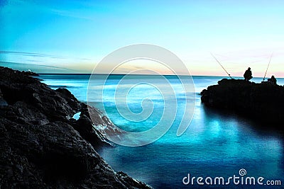 Peace sunset magic hour sea blue fishing rocks Editorial Stock Photo
