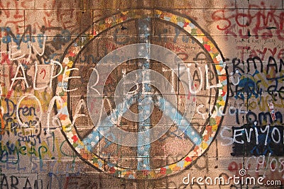 Peace symbol and graffiti spray-painted on wall Stock Photo