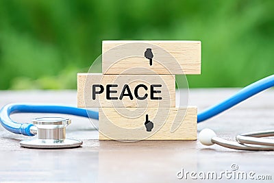PEACE text on wooden blocks on a green background Stock Photo
