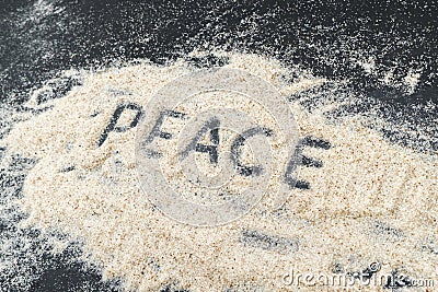 PEACE text written on white sand Stock Photo