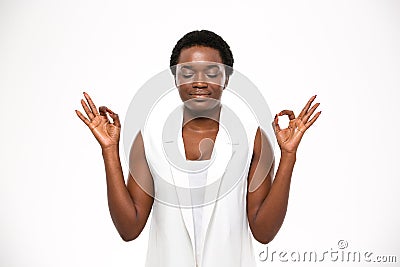Peaceful attractive african american young woman meditating and keeping calm Stock Photo