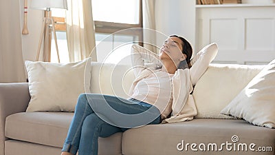 Peaceful attractive woman leaning back, resting on cozy couch Stock Photo