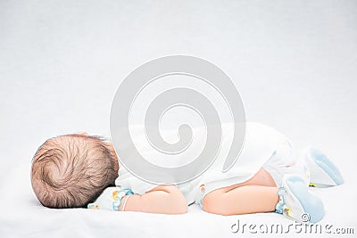 Peaceful baby lying on a bed while sleeping. Stock Photo