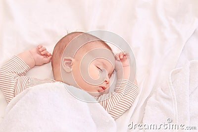 Peaceful baby lying on a bed while sleeping in a bright room Stock Photo