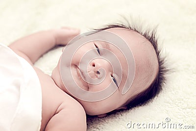 Peaceful baby lying on a bed while sleeping in a bright room Stock Photo