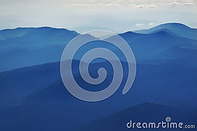 Peaceful blue nature background with foggy Bucegi mountains in Carpathians, Romania Stock Photo