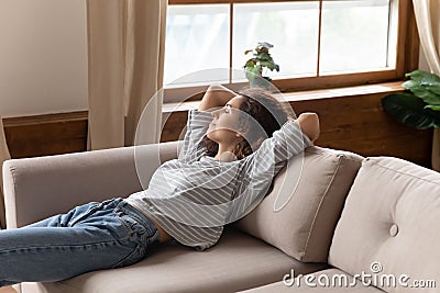 Peaceful calm young woman relaxing on cozy couch alone Stock Photo