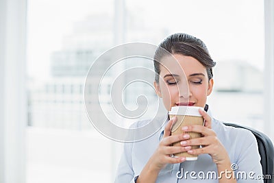 Peaceful classy brown haired businesswoman enjoying coffee smell Stock Photo