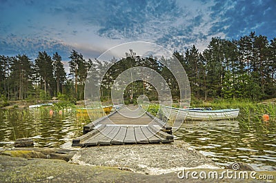 Peaceful cloud landscape on wooden pathway through the lake water and water reflection of stadinding cannoe during the sunset Stock Photo