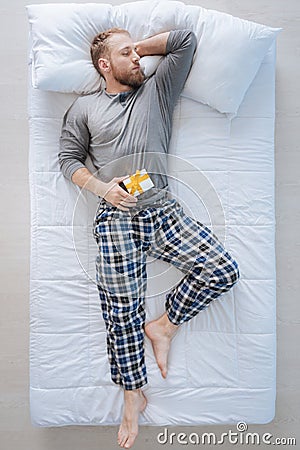 Peaceful handsome man lying with the gift box Stock Photo