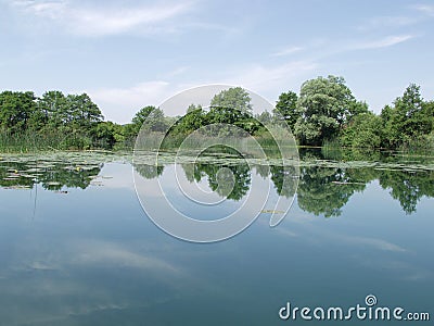 Peaceful lake with clouds reflected in water Stock Photo