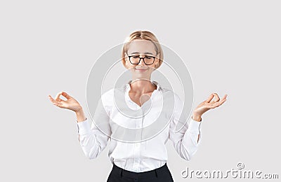 Peaceful mature businesswoman in formal wear meditating on light grey studio background Stock Photo