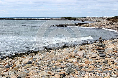 Peaceful scene of rocky shore with waves making their way to the beach Stock Photo