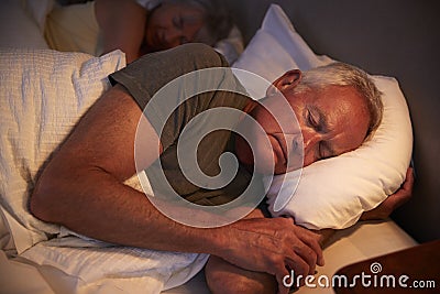 Peaceful Senior Man Asleep In Bed At Night Stock Photo