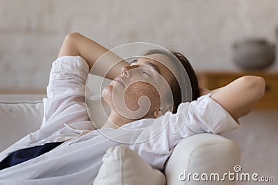 Peaceful sleepy freckled girl resting on comfortable sofa Stock Photo