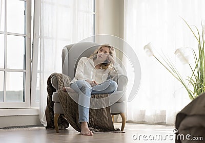 Peaceful sleepy pretty young woman resting in comfortable armchair Stock Photo