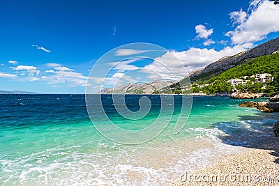 Peaceful and transparent summer sea, mountainous landscape in the background Stock Photo