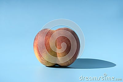 Peach on a blue background as a female body shape like buttocks, thighs, pelvis, pubis. Metaphor of sex, sexuality Stock Photo