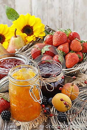 Peach, blueberry and strawberry jams in glass jars Stock Photo