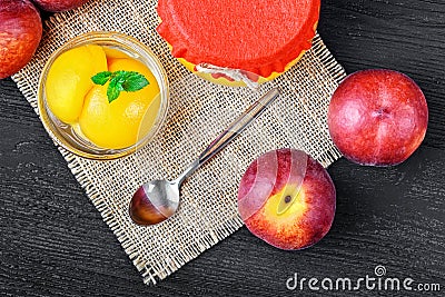 Peach compote with half peaches in glass jars on an old black wooden table Stock Photo