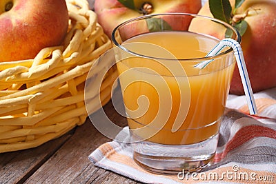 Peach juice in glass closeup on a table and fruit. Horizontal Stock Photo
