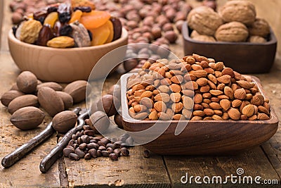 Peach kernel peeled in wooden bowl on table, grunge style Stock Photo