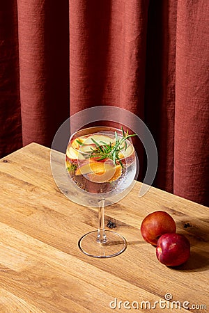 Peach and rosemary Gin Tonic summer cocktail in a glass Stock Photo
