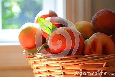 Peaches up close a basket of peaches by a kitchen window Stock Photo
