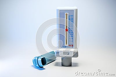 Peak flow meter and a blue inhaler, medical devices for patients with asthma allergy or COPD, light gray background with copy Stock Photo