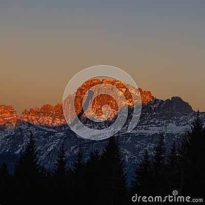 The peak of the mountains of the dolomites during sunset. High mountain landscape of the Dolomites in winter. Fantastic orange Stock Photo