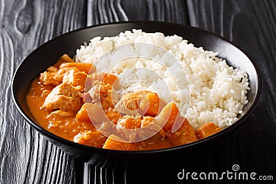 Peanut Domoda stew cooked with chicken pumpkin and a side dish of rice closeup in a plate. horizontal Stock Photo