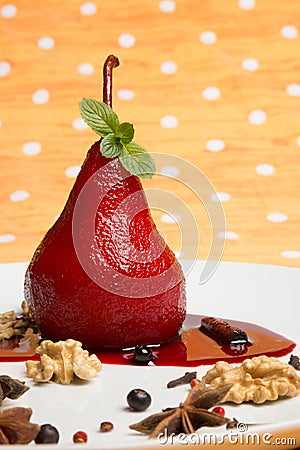 Pear flavored with red wine with Brachetto syrup and crunch nuts Stock Photo